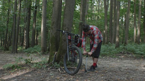 A Man Using an Air Pump for His Bicycle