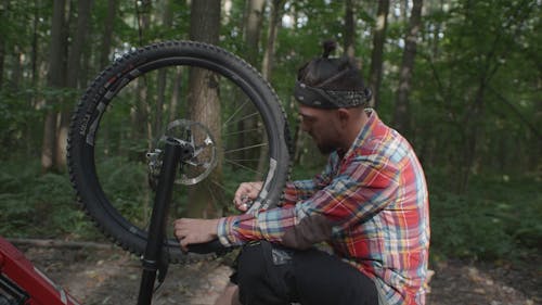 A Man Fixing His Bike
