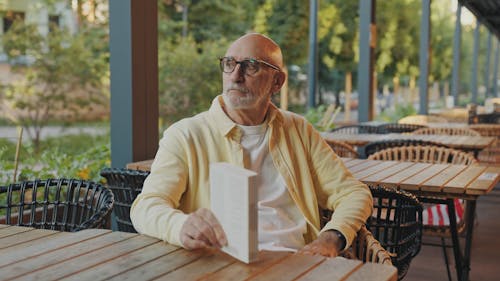 An Elderly Man Waiting at a Table