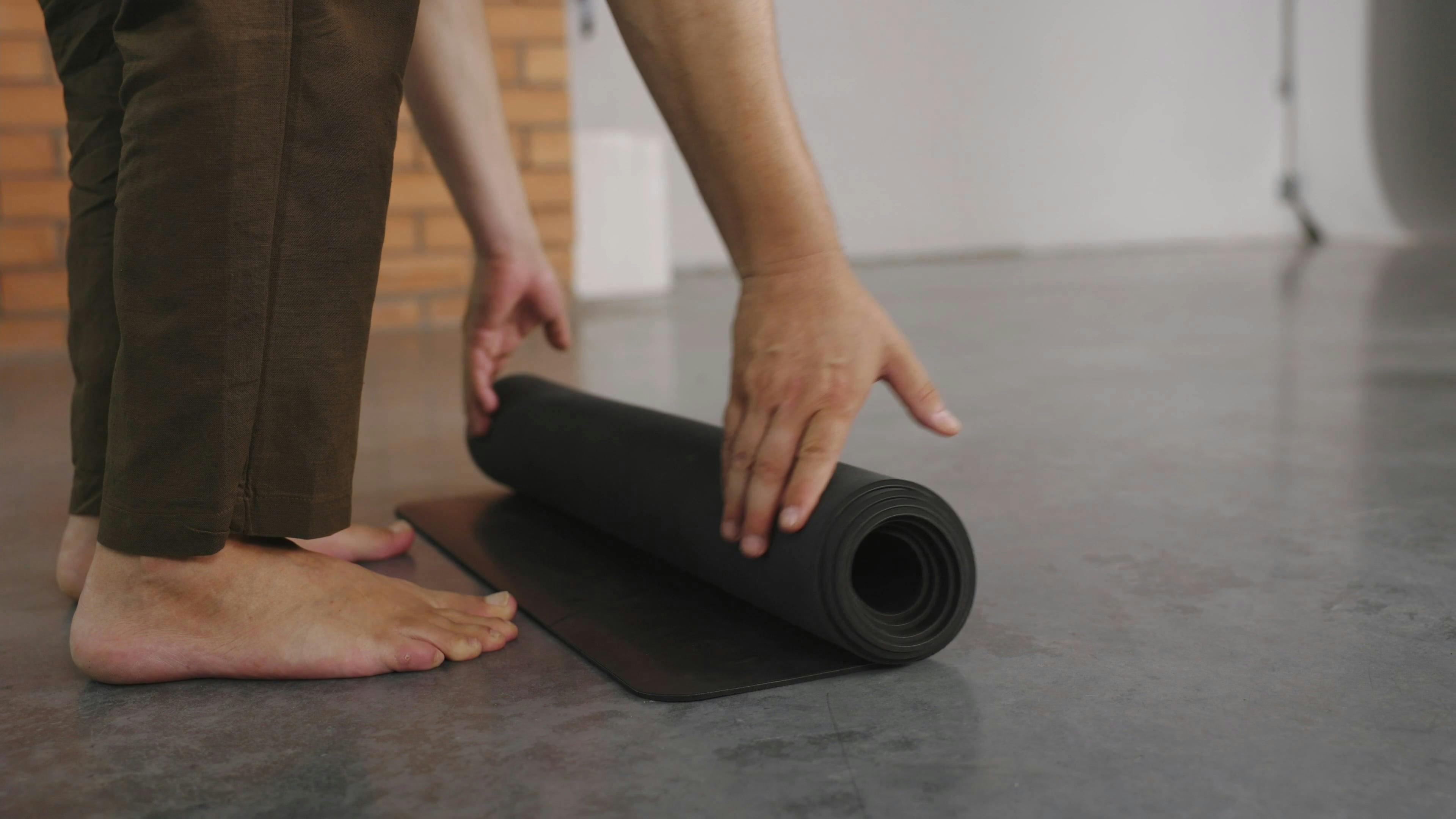 A Person Rolling Out a Yoga Mat · Free Stock Video