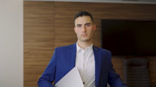 A Man Wearing Business Attire while Holding a Laptop