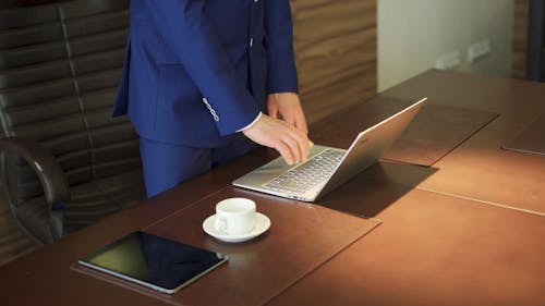 A Man in Corporate Attire Typing on a Laptop