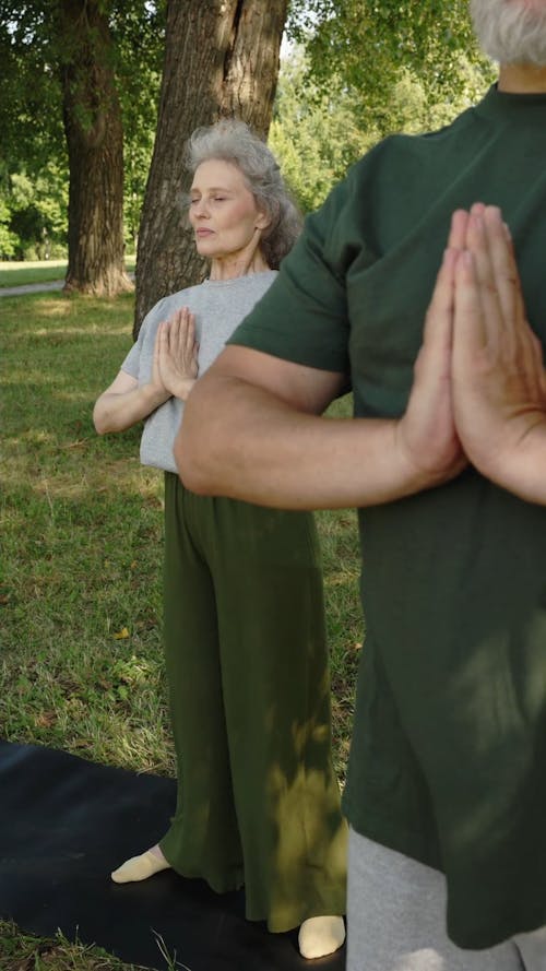 An Elderly Woman Doing the Prayer Pose at a Park