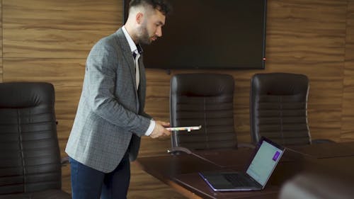 A Man Picking up a Planner on a Table