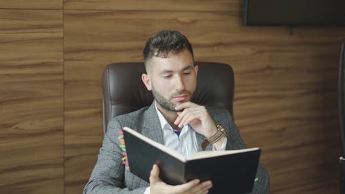 A Man Looking at his Organizer in an Office