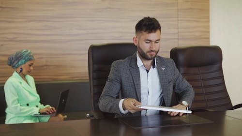 A Man Opening a Laptop on a Table