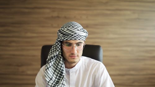 A Man Wearing Hijab while Looking at Laptop