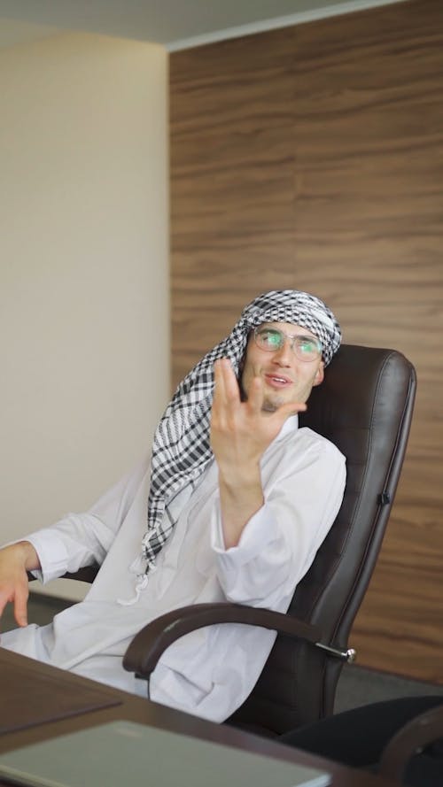 A Man Talking and Doing Hand Gestures while Sitting in an Office Chair