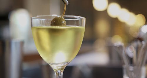 A Person Putting Chardonnay in a Cocktail Drink