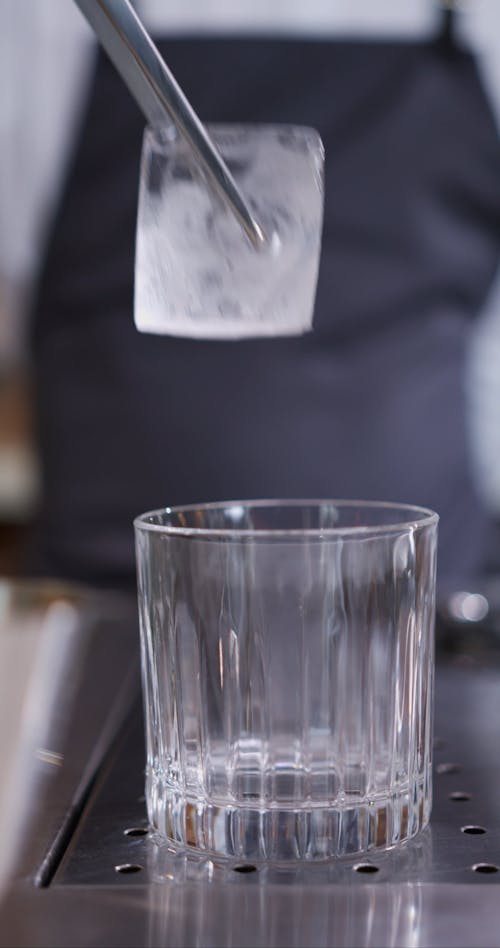 Bartender Putting an Ice Cube into a Glass