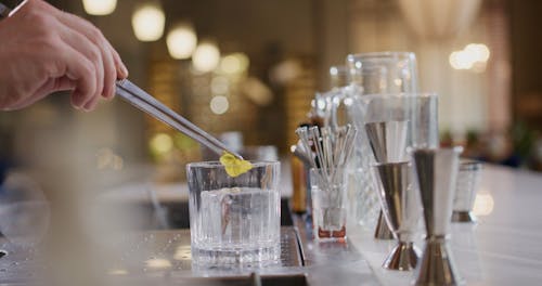 A Person Putting Flower on the Ice Cube in the Glass