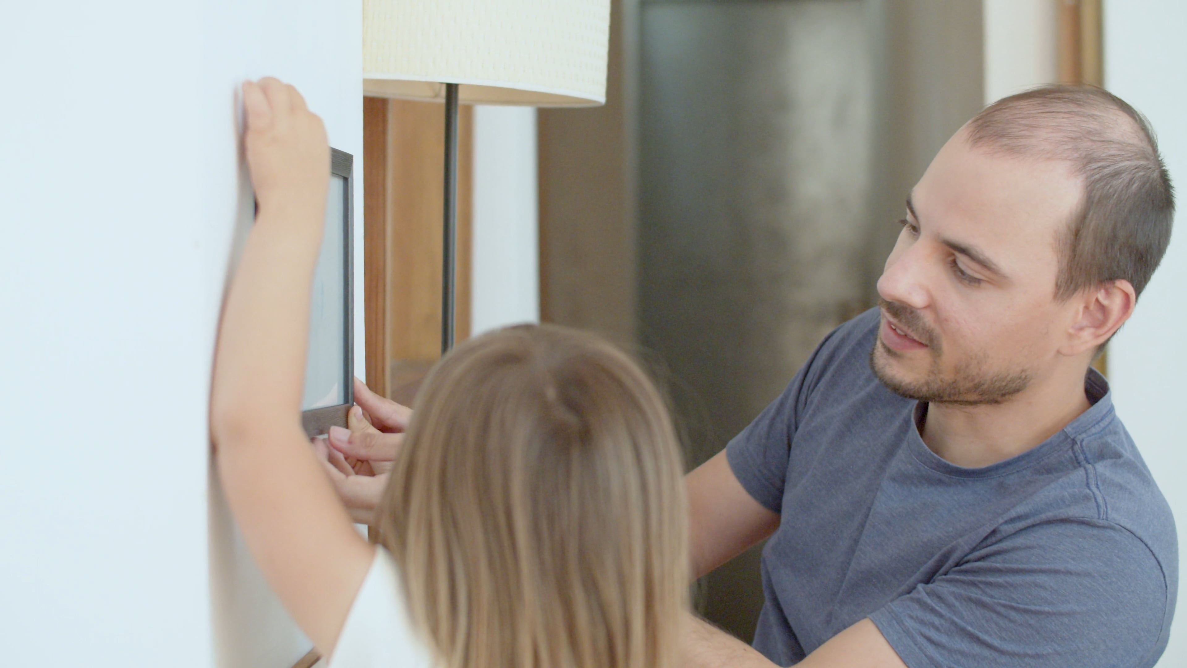 A Man Putting up a Picture Frame with his Daughter Free Stock Video ...