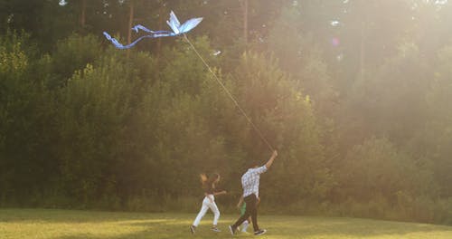A Family Running While Holding a Butterfly Kite
