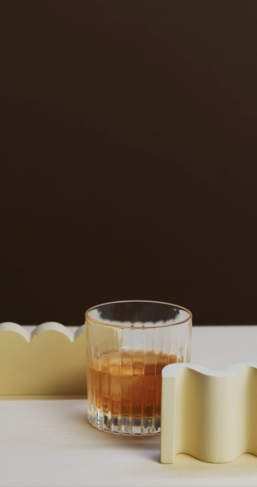 A Person Stirring Whiskey on the Rocks