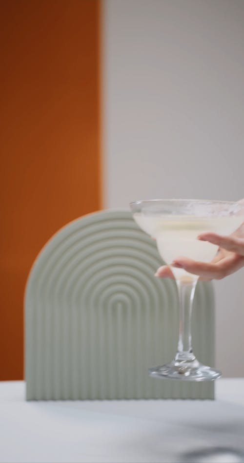 Hand Placing Alcoholic Drink on the Table 
