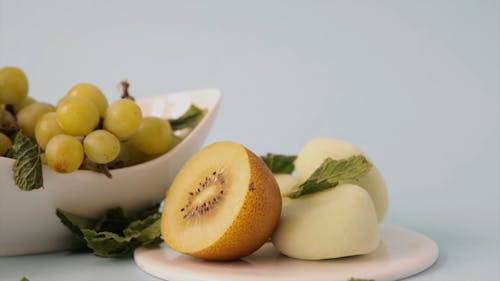 Half of a Golden Kiwi and Green Grapes