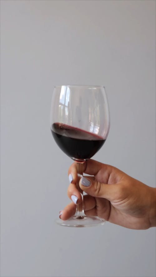 Close up of a Hand Swirling a Glass of Wine