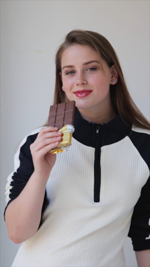 A Woman Eating a Bar of Chocolate
