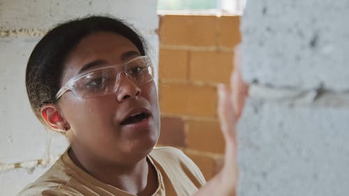 Woman Tapping a Cement Wall
