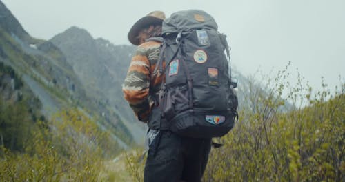 A Backpacker Walking on an Rocky Terrain