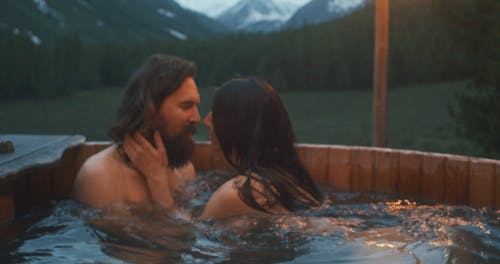 A Couple in an Outdoor Hot Tub Looking at a Scenic View