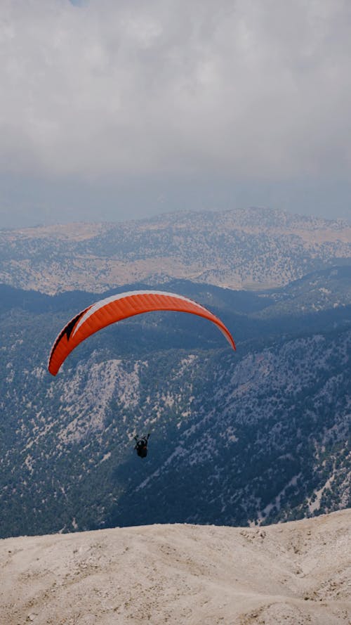 A Person Paragliding with the View of the Mountains