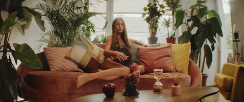 A Woman Turning Over an Hourglass on a Coffee Table