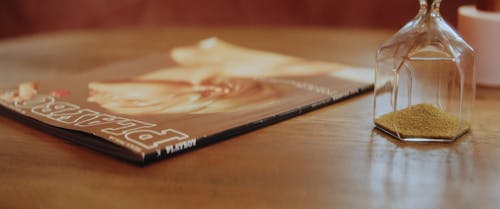 A Sand Glass and a Magazine on the Table