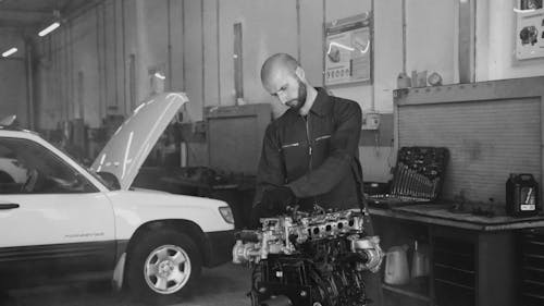 Black and White Video of a Mechanic Working on a Engine