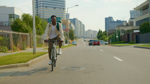 Man Carrying a Thermal Bag While Riding a Bicycle