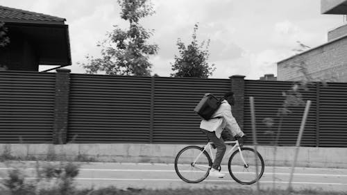 Man Riding a Bicycle While Carrying a Thermal Bag