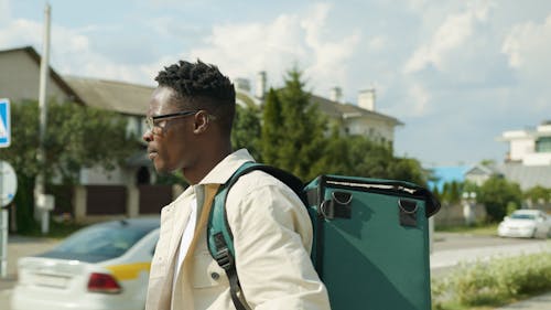 Man Talking on the Phone While Carrying a Thermal Bag