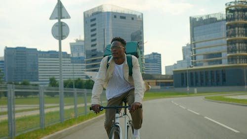 Man Riding a Bicycle While Carrying a Thermal bag