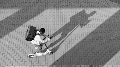 A Delivery Man Looking at His Smartphone 