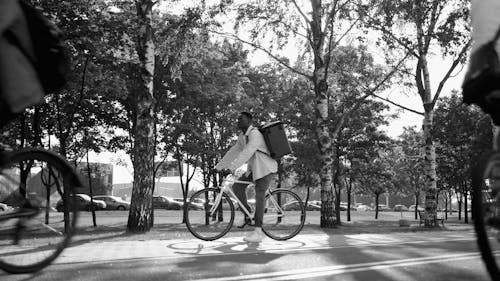 Man Sitting on Bike While Carrying a Thermal Bag
