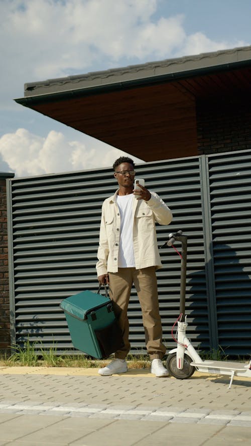 A Courier Looking at his Smartphone 