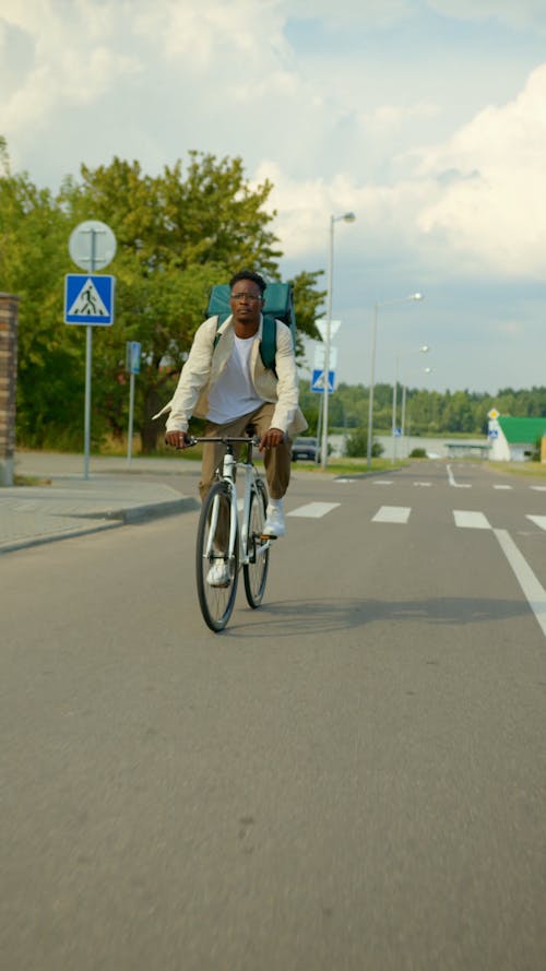 A Male Courier Riding his Bicycle