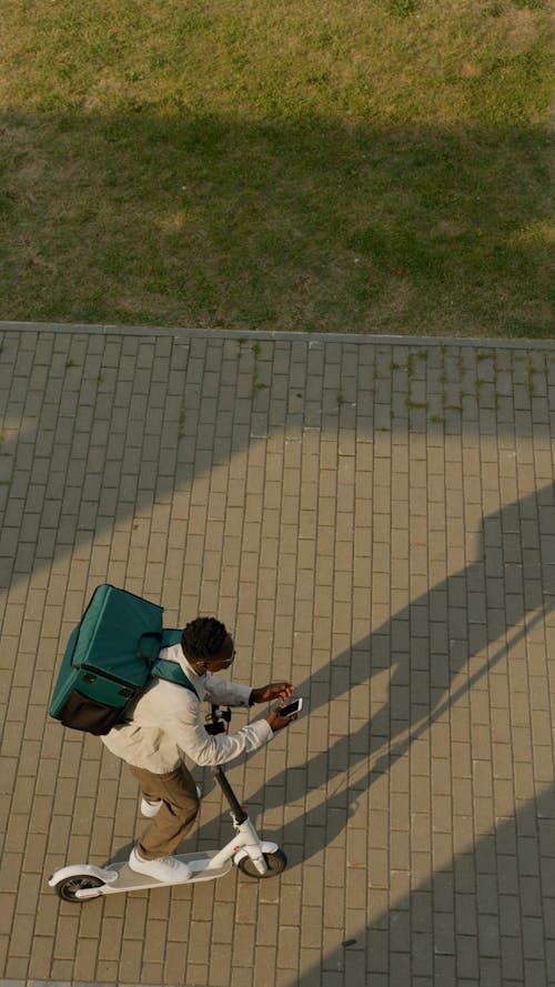 Man Carrying Thermal Bag While Using Cellphone