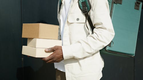 Person Carrying Thermal Bag While Holding Parcels
