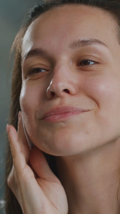 Woman Cleaning Her Face with Cotton Pad