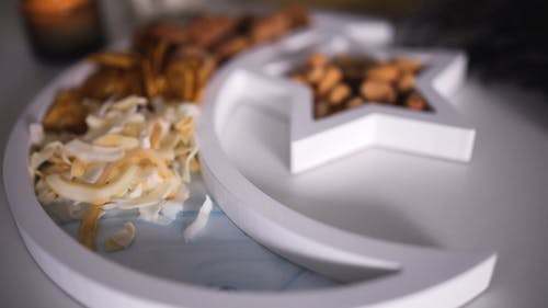 A Person Putting Cashew Nuts on a Plate