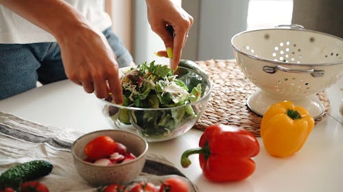 Person Mixing Salad in a Bowl