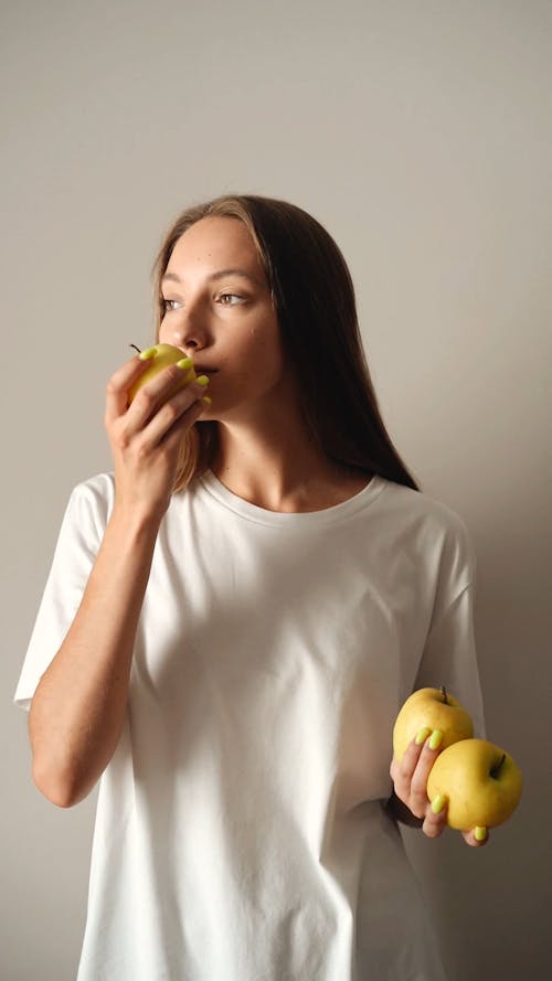 A Woman Smelling a Pear