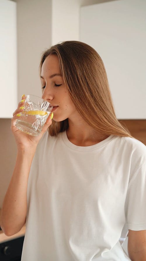 A Woman Drinking Water with Lemon