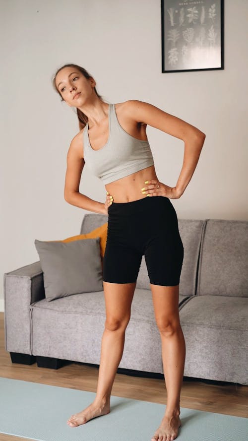 A Woman in Activewear Stretching 