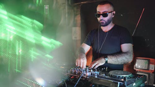 A Disc Jockey Wearing Sunglasses Mixing Sound