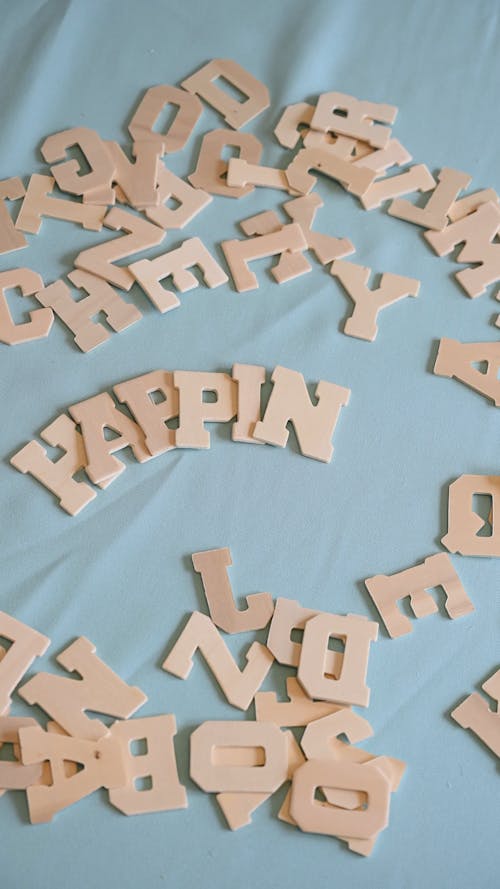 A Person Putting Wooden Letters on a Surface