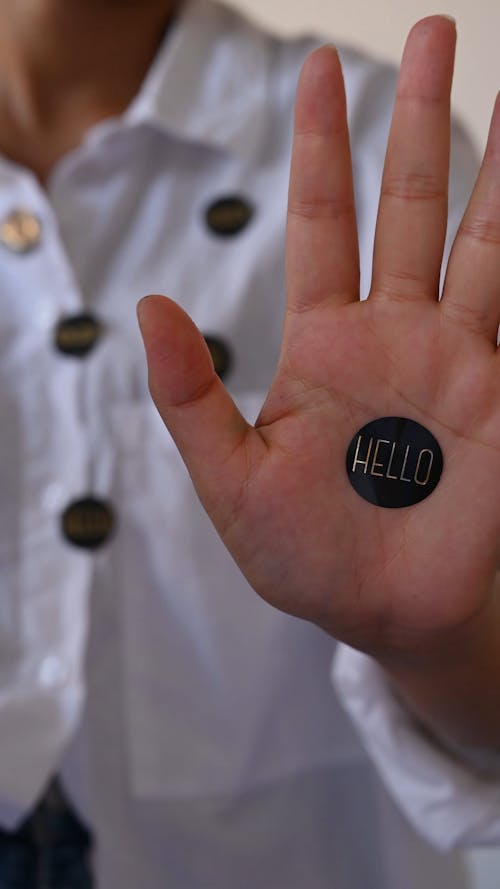 A Person's Hand With Hello Sticker