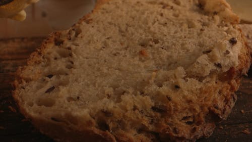 A Person Spreading Butter on a Bread 