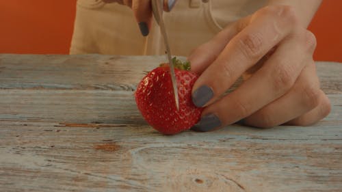 Person Slicing a Strawberry